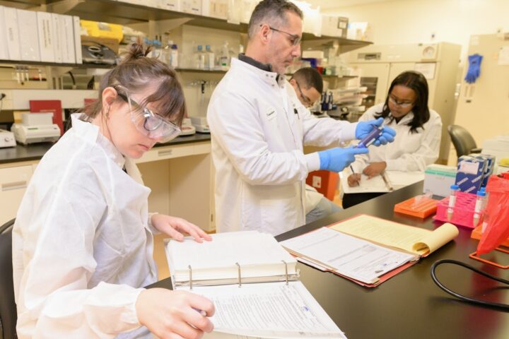 a group of people in lab coats working in a lab